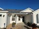 White house with gray roof, two-car garage, and landscaped yard at 3165 Hudson Ct, The Villages, FL 32162