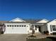 White house with gray roof, two-car garage, and landscaped yard at 3165 Hudson Ct, The Villages, FL 32162