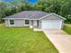 Aerial view of a gray house with a white garage door and green lawn at 4482 Sw Clearwater Ct, Dunnellon, FL 34431