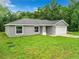 Aerial view of a gray house with a white garage door and green lawn at 4482 Sw Clearwater Ct, Dunnellon, FL 34431