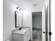 Bathroom with granite countertop, white vanity, and rectangular mirror at 4482 Sw Clearwater Ct, Dunnellon, FL 34431