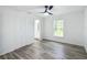 Bright bedroom with wood-look vinyl flooring, ceiling fan, and access to bathroom at 4482 Sw Clearwater Ct, Dunnellon, FL 34431