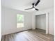 Light bedroom with wood-look floors, ceiling fan, and walk-in closet at 4482 Sw Clearwater Ct, Dunnellon, FL 34431