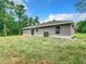 House exterior showcasing gray siding and grassy yard at 4482 Sw Clearwater Ct, Dunnellon, FL 34431