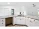 L-shaped kitchen with granite countertops and white cabinets at 4482 Sw Clearwater Ct, Dunnellon, FL 34431