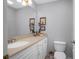 Clean bathroom with white cabinets and a beige countertop at 4925 Cr 309B, Lake Panasoffkee, FL 33538