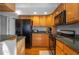 View of kitchen with dark appliances and wood cabinets at 4925 Cr 309B, Lake Panasoffkee, FL 33538