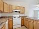 White appliances and wood cabinets in this galley kitchen at 5 Walnut Ct, Ocala, FL 34480