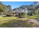 Home's backyard with screened patio and lush landscaping at 5224 Se 44Th Cir, Ocala, FL 34480