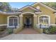 Front entry with brick walkway and elegant black door at 5224 Se 44Th Cir, Ocala, FL 34480