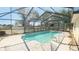 Sparkling in-ground pool surrounded by a screened enclosure with a concrete patio at 5491 Sw 100Th Loop, Ocala, FL 34476