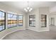 Spacious dining room with large windows, chandelier, and wood-look flooring at 5525 Sw 80Th Pl, Ocala, FL 34476