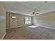 Bright living room features neutral carpet and ceiling fan at 6363 Nw 61 Ave, Ocala, FL 34482