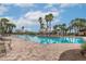 Large community pool surrounded by palm trees, lounge chairs, and beautiful sunny skies at 6758 Sw 94Th Cir, Ocala, FL 34481