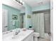 Charming bathroom with light teal walls and a floral shower curtain at 8137 Sw 117Th Loop, Ocala, FL 34481