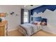 Bedroom with mountain-themed wall and striped bedding at 8489 Las Palmas Way, Wildwood, FL 34785