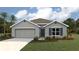 Single-story home with gray siding, two-car garage, and landscaped yard at 8489 Las Palmas Way, Wildwood, FL 34785