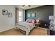 Well-lit bedroom with a metal bed frame and dark accent wall at 8493 Las Palmas Way, Wildwood, FL 34785