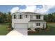 Two-story house with light gray siding, shutters, and a two-car garage at 8493 Las Palmas Way, Wildwood, FL 34785