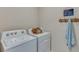 Functional laundry room with washer, dryer, and hanging rack at 8493 Las Palmas Way, Wildwood, FL 34785