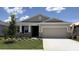 Charming single-story home with a well-manicured lawn and a two-car garage at 8562 Pinecrest Trl, Wildwood, FL 34785