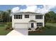 Two-story house with a white exterior, navy blue accents, and a two-car garage at 8894 Sw 48Th Ave, Ocala, FL 34476