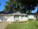 Charming light blue house with well-maintained landscaping and a two-car garage at 11490 Sw 85Th Ave, Ocala, FL 34481