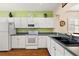 Kitchen with white cabinets, black countertops and appliances at 12498 Se 92Nd Ave, Summerfield, FL 34491