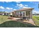 Brick paved patio with seating and a grill, adjacent to a grassy area at 12498 Se 92Nd Ave, Summerfield, FL 34491