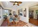 Sunroom with glass-top table and wicker chairs, offering views of the backyard and interior at 12498 Se 92Nd Ave, Summerfield, FL 34491