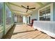 Screened porch with wood flooring, ceiling fan, and backyard view at 21654 Sw Honeysuckle St, Dunnellon, FL 34431