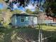 Front view of a light blue house with a chain link fence and landscaping at 2211 Sw 1St St, Ocala, FL 34475