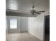 Bright living room with light flooring, a ceiling fan, and access to other rooms at 2211 Sw 1St St, Ocala, FL 34475