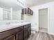 Bathroom with dark wood cabinets, double vanity, and linen closet at 2457 Bulrush Dr, Saint Cloud, FL 34769