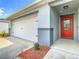 White two-car garage with a red front door at 2457 Bulrush Dr, Saint Cloud, FL 34769