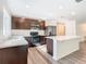 Modern kitchen with island, stainless steel appliances, and dark wood cabinets at 2457 Bulrush Dr, Saint Cloud, FL 34769