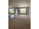 Large living room with carpeted floors and access to the backyard at 421 Spring Ln, Ocala, FL 34472