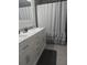 Bathroom with double vanity, shower, and gray tile floors at 4434 Se 10Th Pl, Ocala, FL 34471