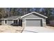 Newly constructed home with gray exterior, stone accents, and a two-car garage at 46 Locust Pass Run, Ocala, FL 34480