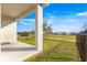 Covered patio overlooking a fenced backyard and community green space at 5325 Sunshine Dr, Wildwood, FL 34785