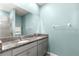 Bathroom with double vanity, granite countertop, and light blue walls at 5325 Sunshine Dr, Wildwood, FL 34785