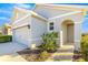 Front view of a house with gray exterior, arched entryway, and landscaping at 5325 Sunshine Dr, Wildwood, FL 34785