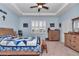 Spacious bedroom with light blue walls, wooden furniture, and a ceiling fan at 6158 Sw 88Th Loop, Ocala, FL 34476