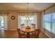 Bright dining area with wood table and chairs, neutral decor, and access to sliders at 8652 Se 133Rd Ln, Summerfield, FL 34491