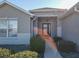 Front entry with a covered porch, dark-colored door, and neatly trimmed landscaping at 8652 Se 133Rd Ln, Summerfield, FL 34491