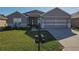 Single-story home with gray exterior, two-car garage, and well-manicured lawn at 8652 Se 133Rd Ln, Summerfield, FL 34491