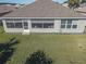 Rear view of house showcasing screened patio and landscaped yard at 8652 Se 133Rd Ln, Summerfield, FL 34491