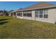 Side view of house with screened patio and manicured lawn at 8652 Se 133Rd Ln, Summerfield, FL 34491