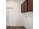 Laundry room with wood-look floors, upper cabinets, and built-in shelving at 8761 Sw 79Th Loop, Ocala, FL 34481