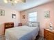 Cozy bedroom featuring a double bed, ceiling fan, and light pink walls at 9050 Sw 190Th Cir, Dunnellon, FL 34432